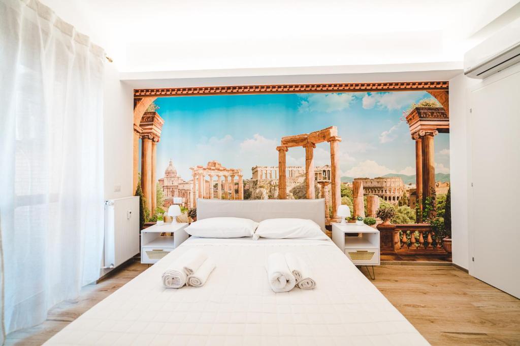 a bedroom with a large white bed with slippers on it at Tibur Domus B&B in Rome