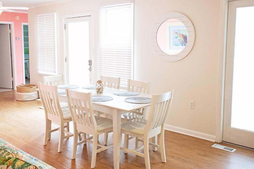 Lorraine's Beach Cottage في كيور بيتش: غرفة طعام مع طاولة بيضاء وكراسي