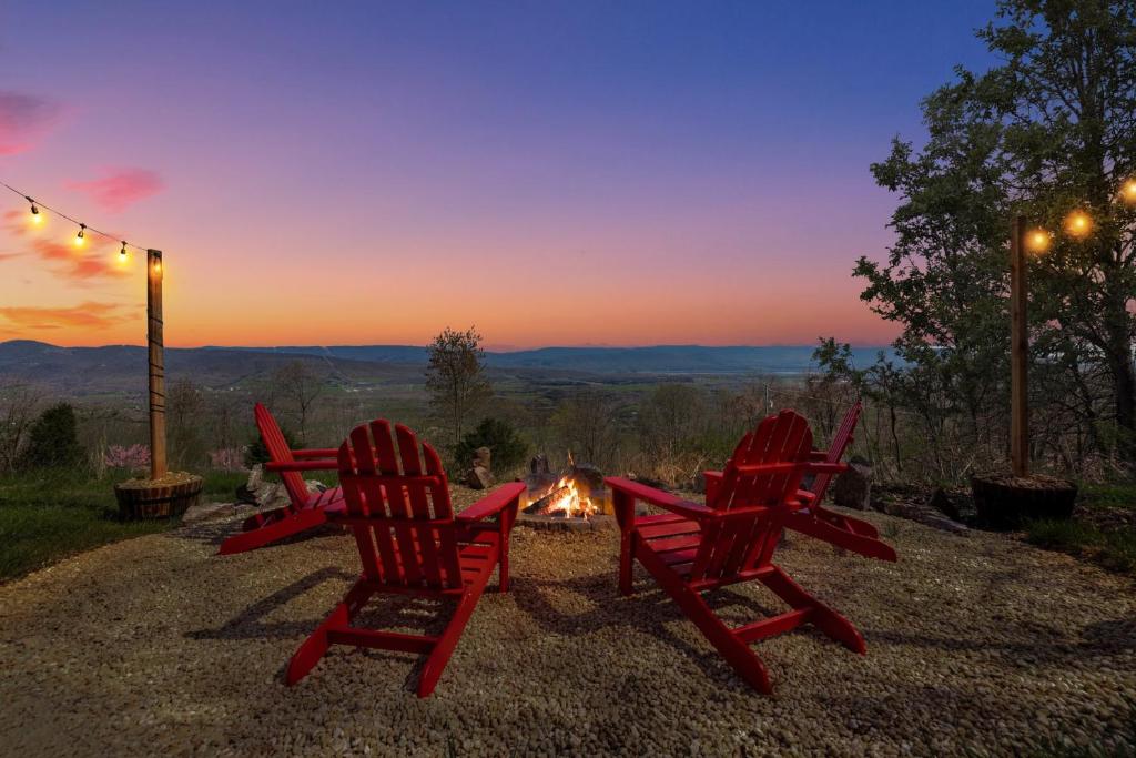 a group of red chairs sitting around a camp fire at Chalet w Stunning Views Hot Tub Fire Pit & WiFi in Old Fields