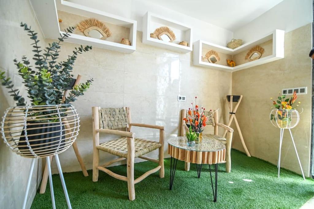 sala de estar con sillas y mesa con flores en The Skyline Stay, en Marrakech