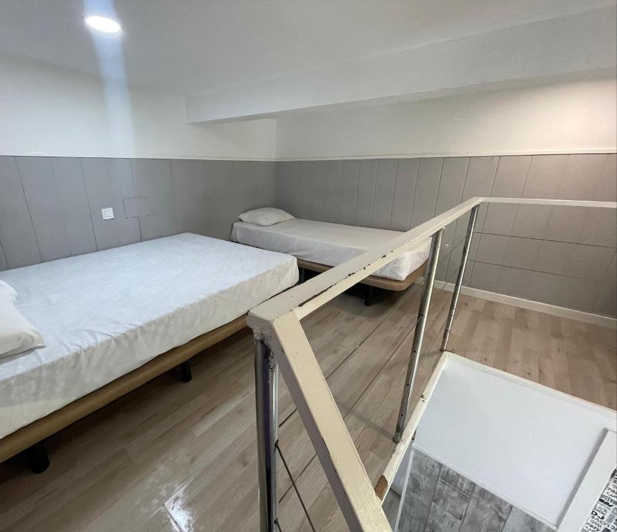 a small room with two beds and a mirror at Estudios sol in Madrid
