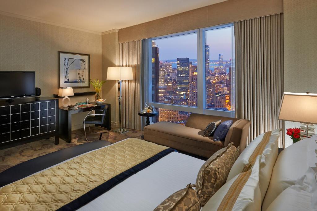 a hotel room with a bed and a large window at Mandarin Oriental, New York in New York
