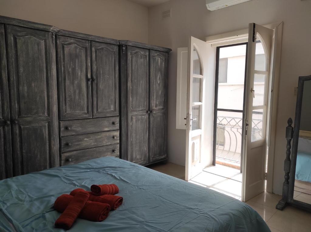 a bedroom with a bed with red gloves on it at Ta' Marija Home in Sliema