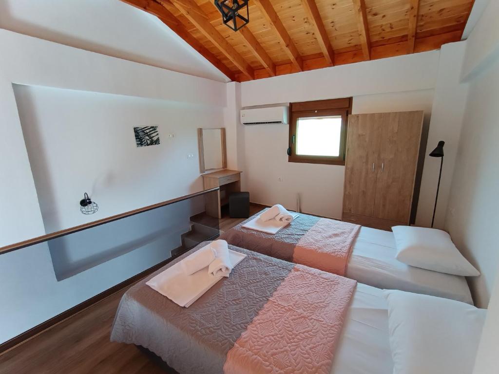 - une chambre avec 2 lits et une fenêtre dans l'établissement VICTORY SUITES, à Samothráki