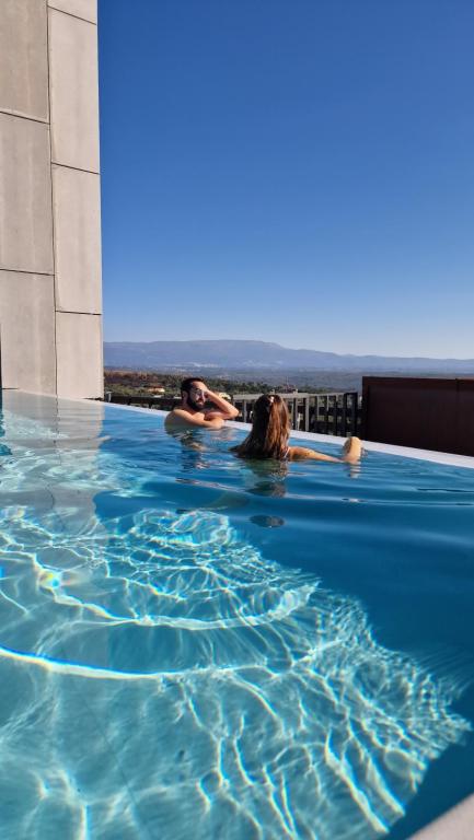 2 personas nadando en una piscina en Puro Dão Hotel & Spa, en Nelas