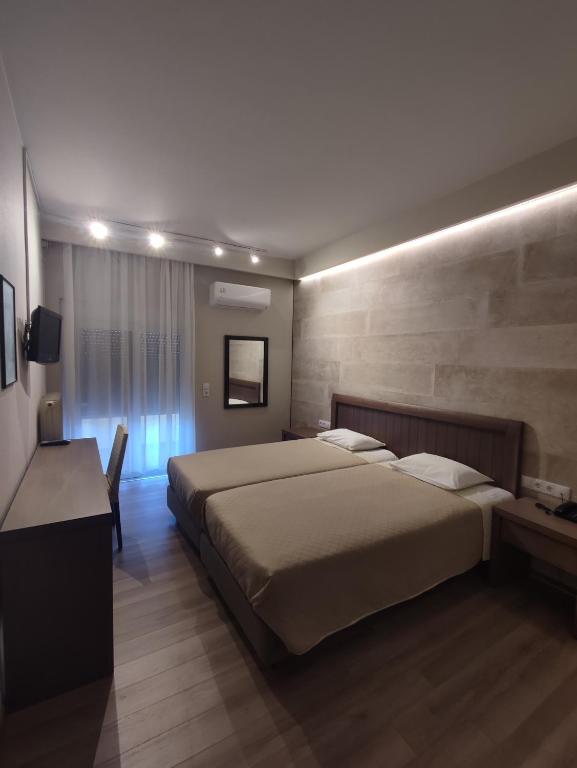 a bedroom with a large bed and a desk and a bed sidx sidx sidx sidx at Plaza Hotel in Alexandroupoli