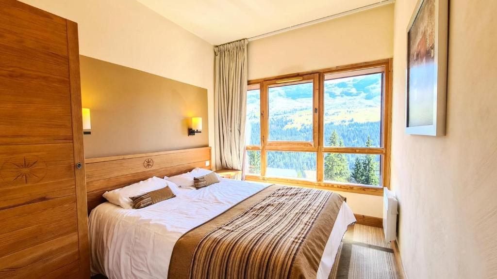 a bedroom with a bed and a large window at Résidence Les Terrasses D'eos - Appartement spacieux · Accès direct aux pistes · Piscine · WIFI gratuit et illimité · Spa MAE-1661 in Magland