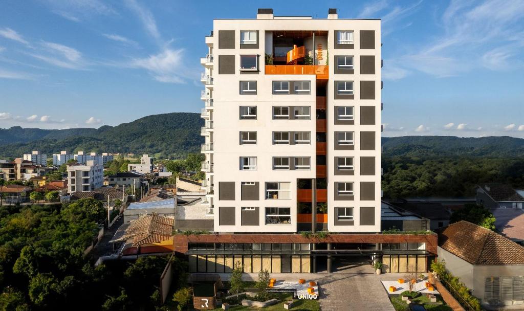 un edificio alto de color blanco con un balcón en la parte superior. en Morcelli Mobiliados - Uniqo Smart Living en Santa Maria
