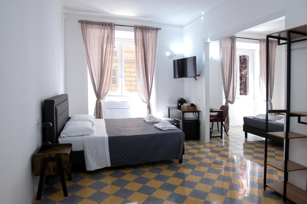 una camera da letto con un letto e una TV in una stanza di Vatican 23 Museum Suites a Roma