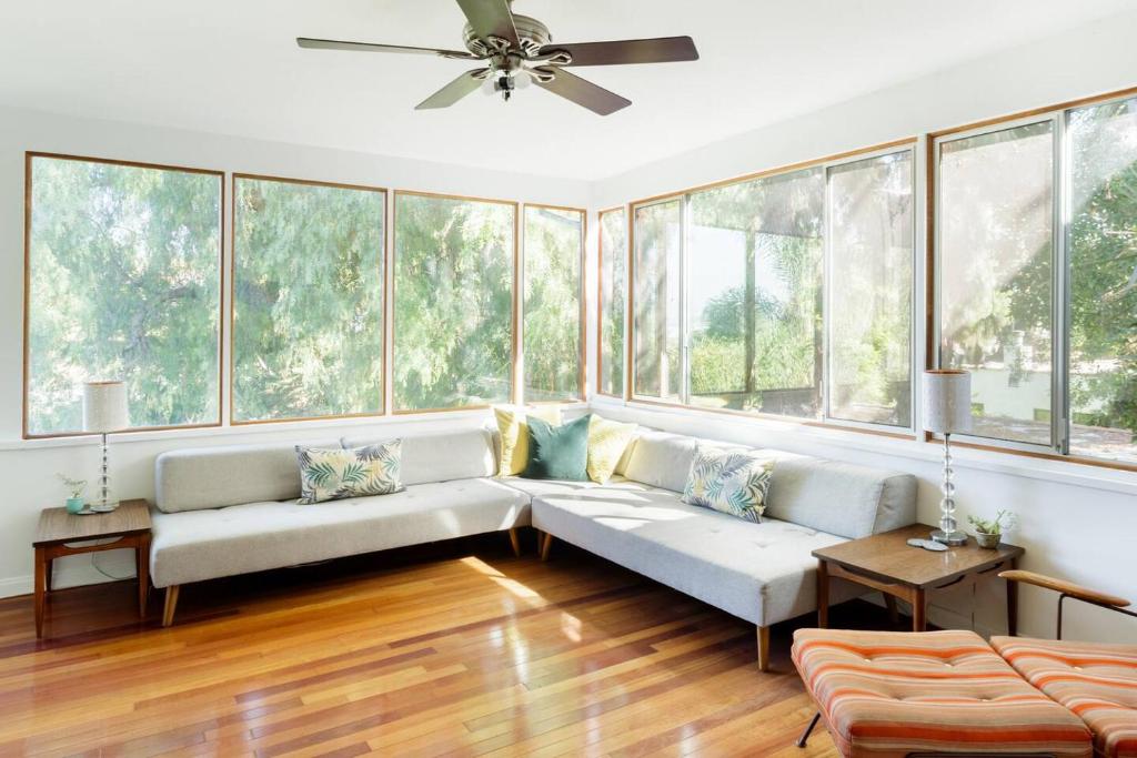 ein Wohnzimmer mit einem Sofa und einigen Fenstern in der Unterkunft Silver Lake Mid-century Nestled In The Treetops in Los Angeles