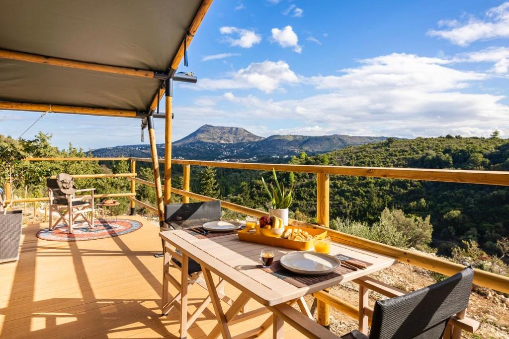 a patio with a table and chairs on a deck at Civara Chalet - Private Glamping in nature with Jacuzzi in Tsivarás