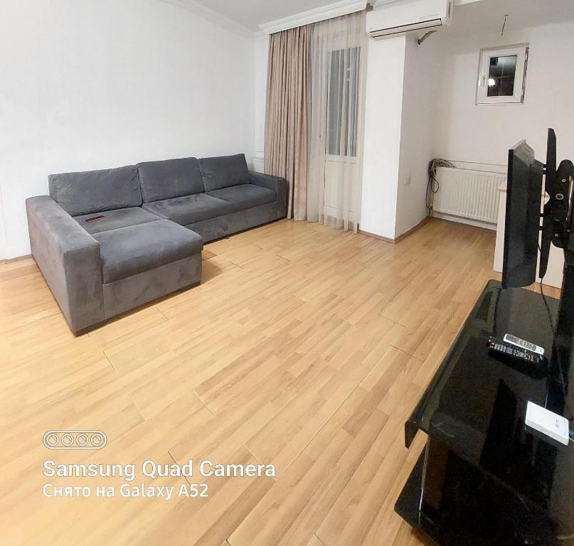 a living room with a couch and a television at Apartment on St. Nikoloz Baratashvili 1 in Batumi