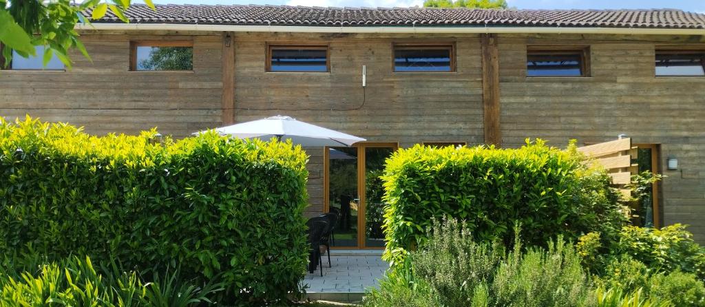 a house with an umbrella in front of it at Buddleia in Cherbonnières
