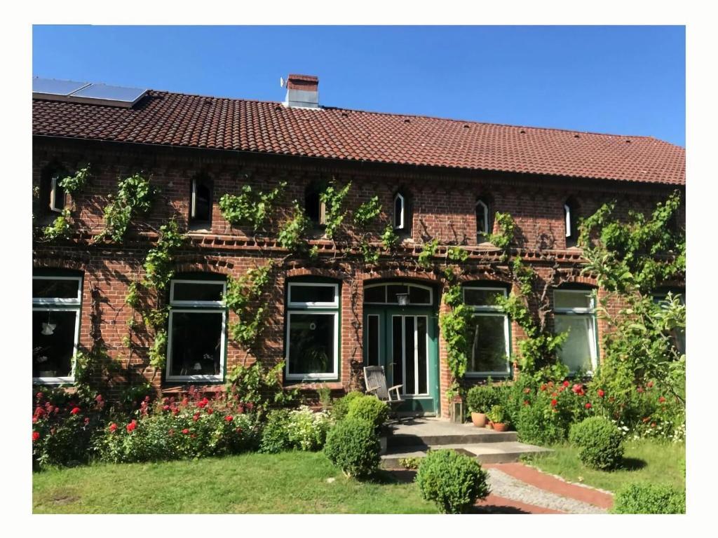 a brick house with ivy on the side of it at Holiday apartment 2 in the Maaßen country house in Stakendorf
