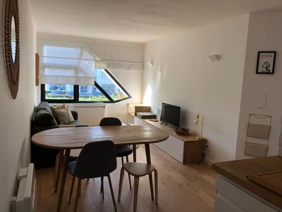 un salon avec une table, des chaises et un canapé dans l'établissement Charmant appartement 15 min de Lille, à Marcq-en-Barœul
