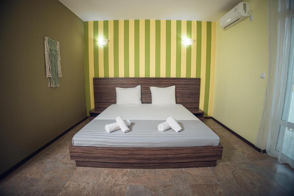 a bedroom with a bed with two pillows on it at Хотел и Вили Марая apartament in Tsarevo