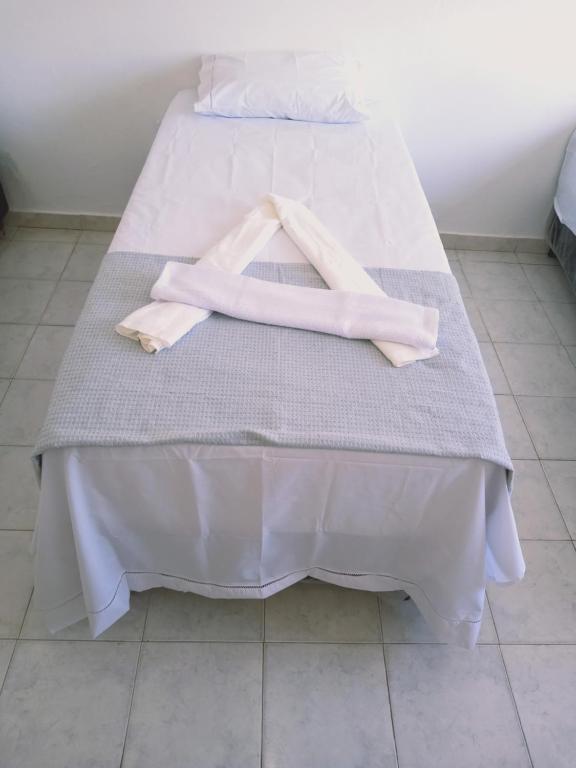 Una cama con dos toallas rosas encima. en Angelus Hotel & Estacionamento, en Campos dos Goytacazes