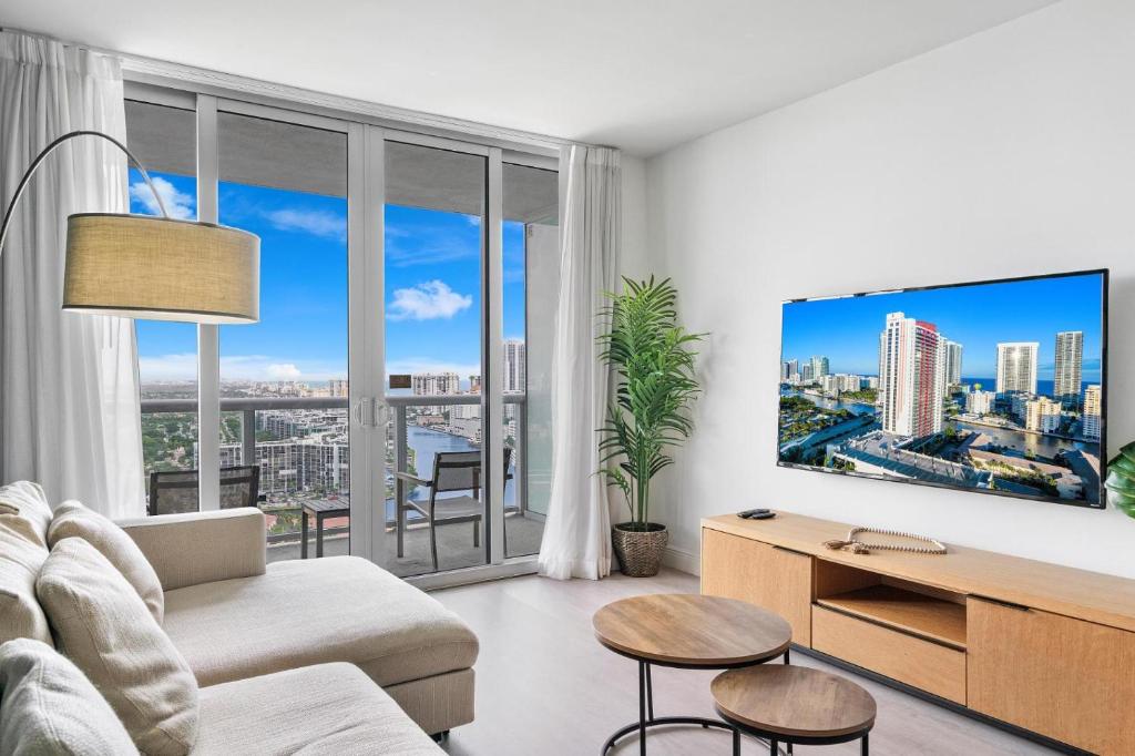 een woonkamer met een bank en een tv bij Panoramic views 2 bed at Beach walk 27th Miami in Hollywood