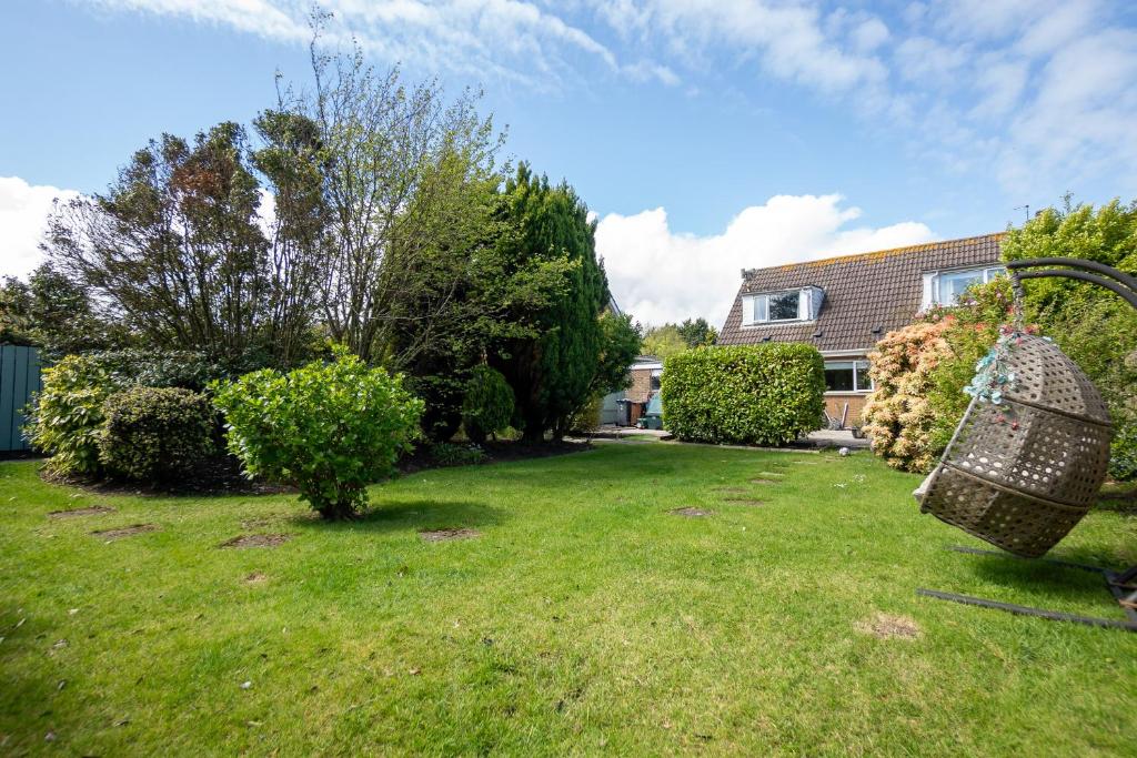 ニューカッスルにあるGolf Links Cottage - Views of Royal County Downの家のある庭とバスケットのある芝生