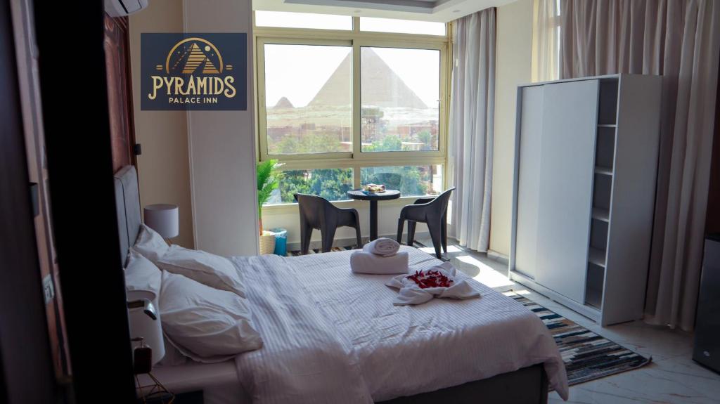 een slaapkamer met een bed met een tafel en een raam bij Pyramids Palace Inn in Caïro