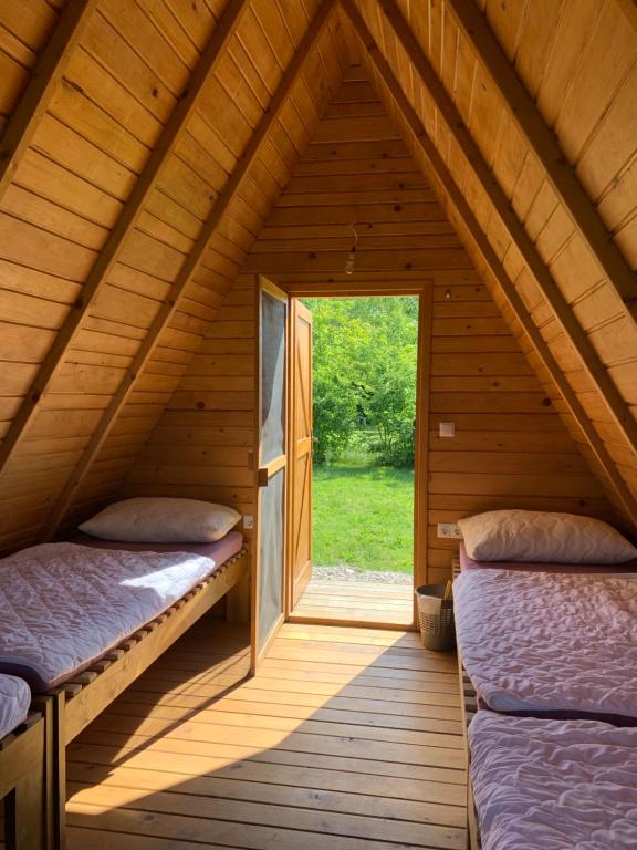 a bedroom in a log cabin with two beds at Kuća za odmor KRNJAIĆ in Bosanski Novi