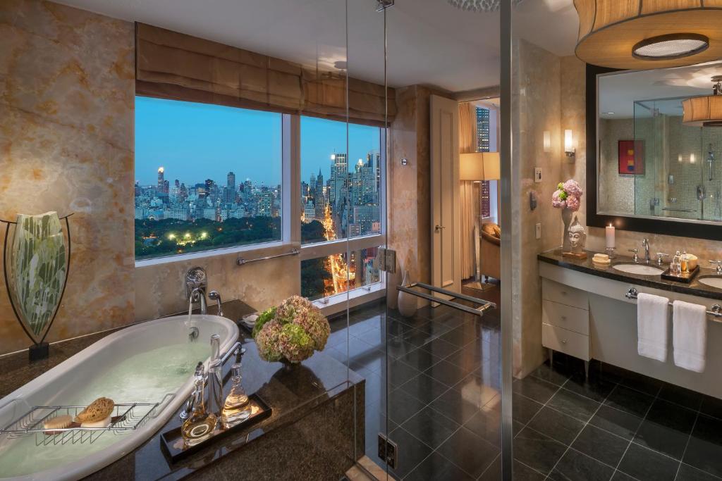 a bathroom with a tub and a view of the city at Mandarin Oriental, New York in New York