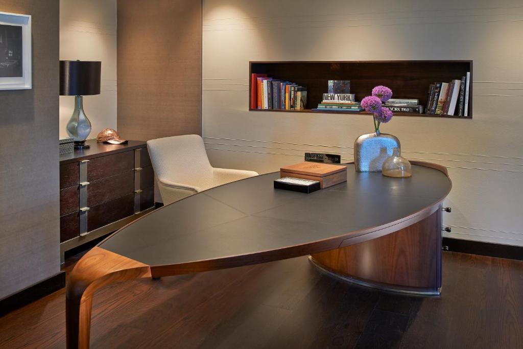 a desk with a vase with a flower in a room at Mandarin Oriental, New York in New York