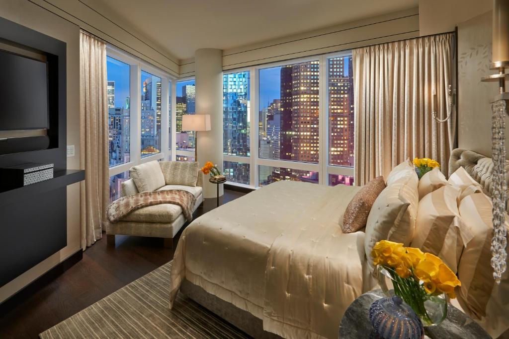 a bedroom with a large bed and a large window at Mandarin Oriental, New York in New York