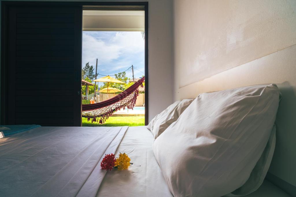 Un dormitorio con una cama con flores. en Pousada Solar da Praia, en Tamandaré