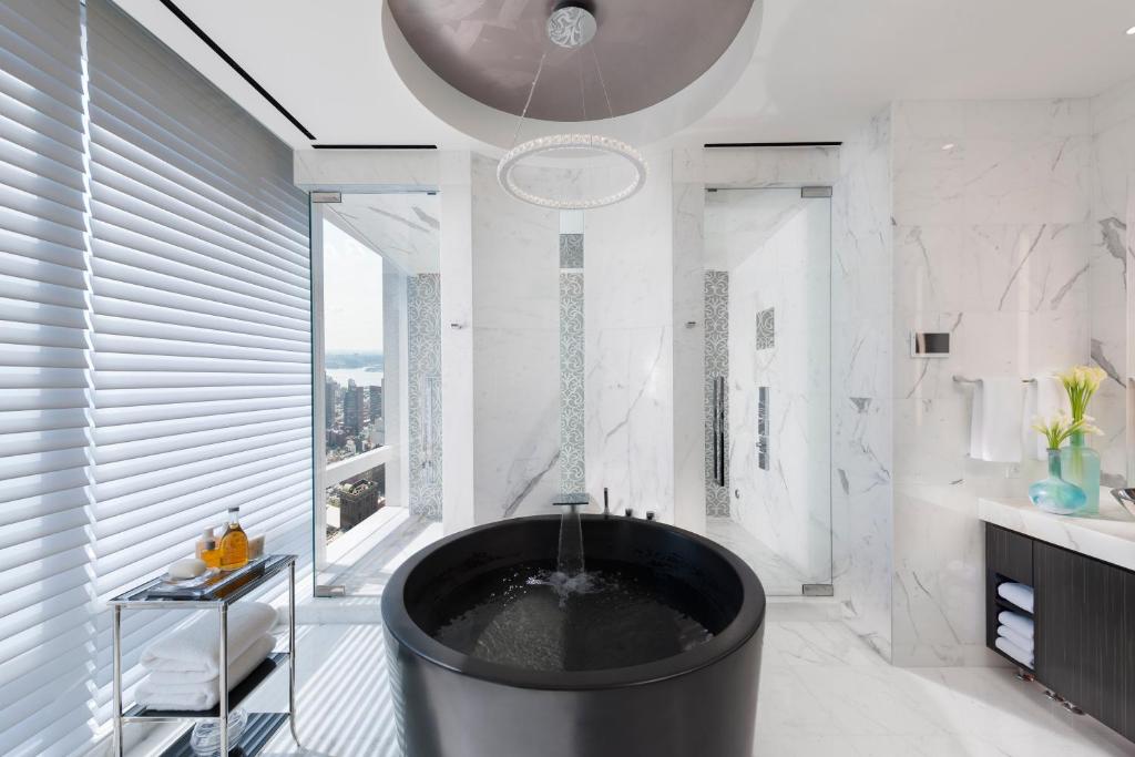 a bathroom with a large tub in the middle at Mandarin Oriental, New York in New York