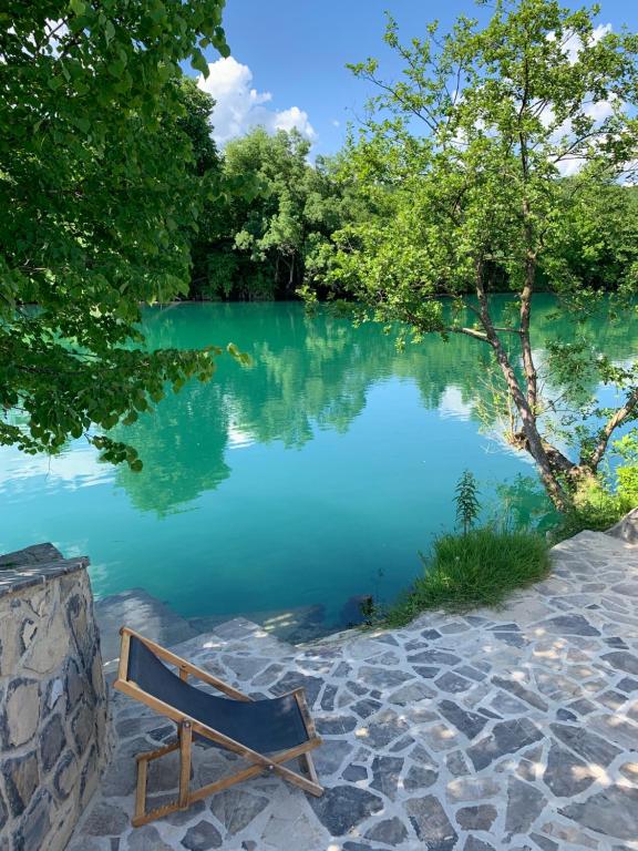 a bench sitting in front of a lake at Kuća za odmor KRNJAIĆ,porodični KAMP in Bosanski Novi