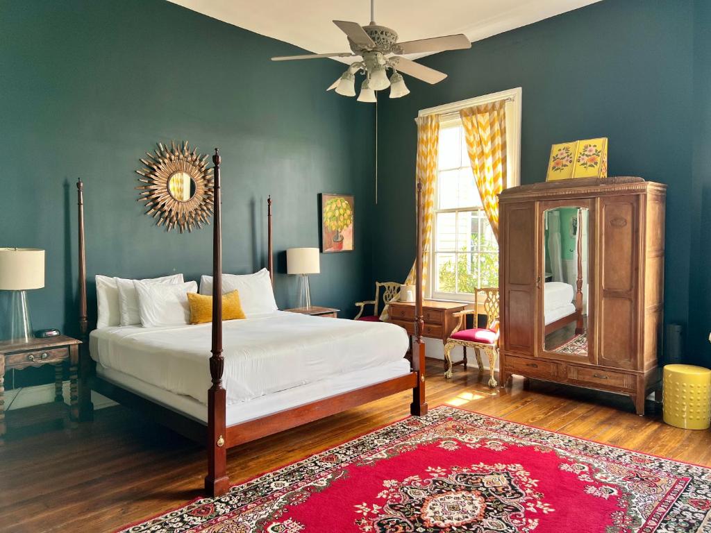 Creole Gardens Guesthouse and Inn في نيو أورلينز: غرفة نوم بسرير ومروحة سقف