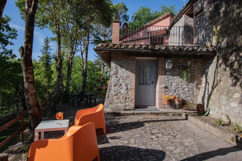 a stone house with a balcony and a table and chairs at Little Umbria Guest House in Ficulle