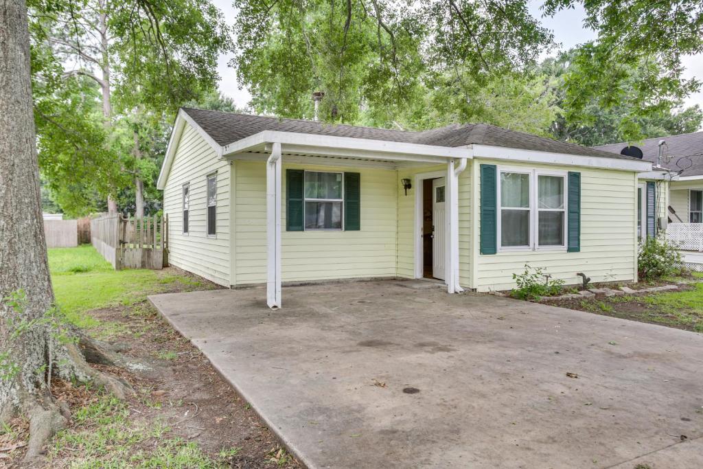 a yellow house with a driveway in front of it at Centrally Located Gonzales Home with Yard! in Gonzales