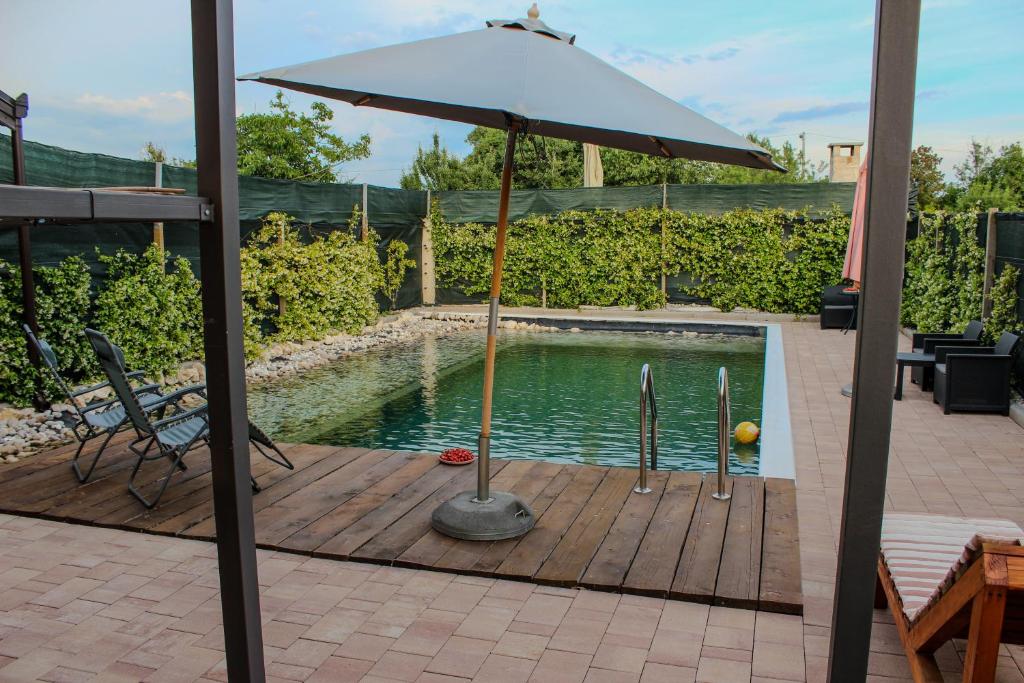 an umbrella sitting on a wooden deck next to a pool at Villa Bali - Aladinici in Stolac