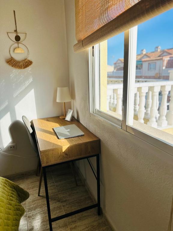 biurko z laptopem obok okna w obiekcie Bungalow Aguas Nuevas Costa del Cezar w mieście Torrevieja