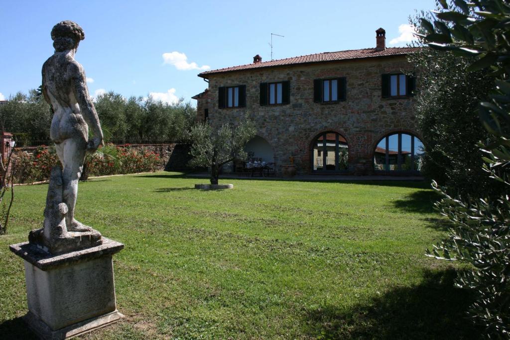 Una statua di una donna davanti a una casa di Casa Felice a Lucignano