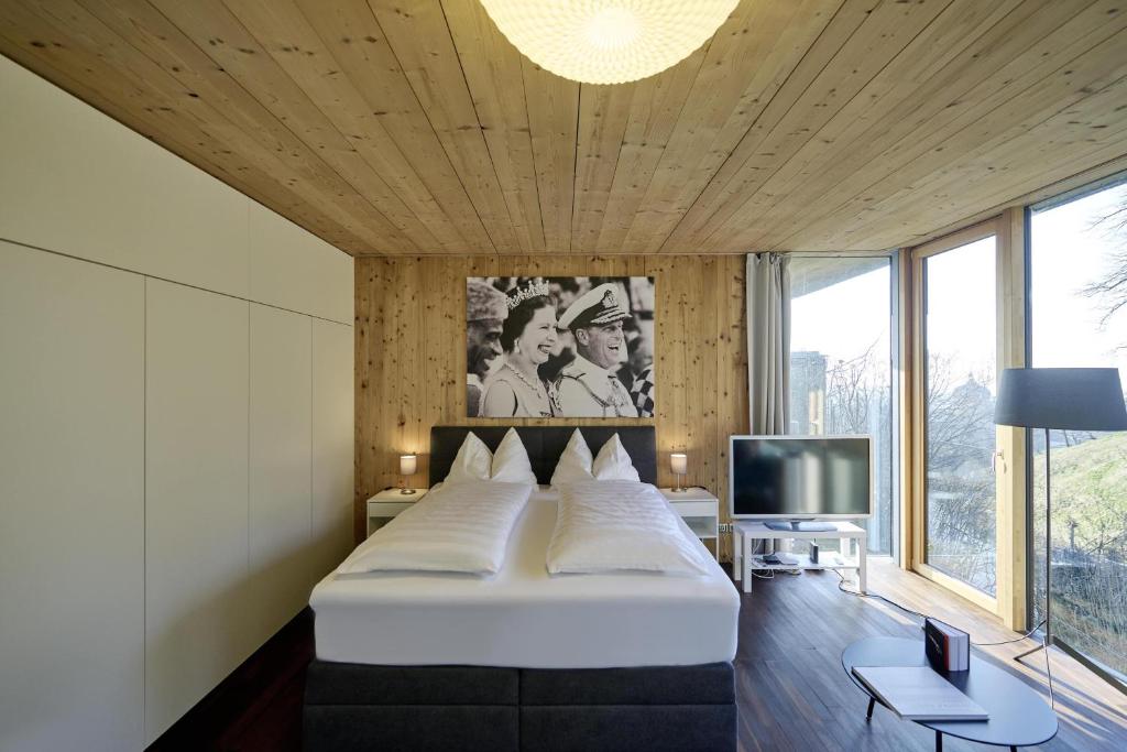 um quarto com uma cama grande e uma televisão em Design Studio Bergisel em Bregenz