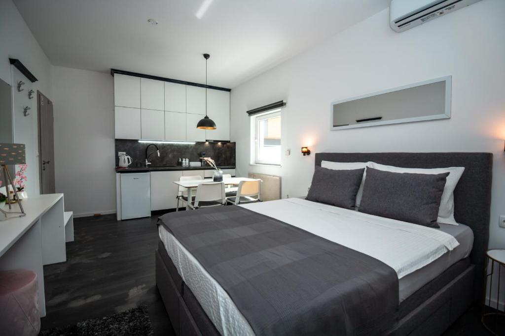 a bedroom with a large bed and a kitchen at Studioapartment Black & White in Velika Gorica
