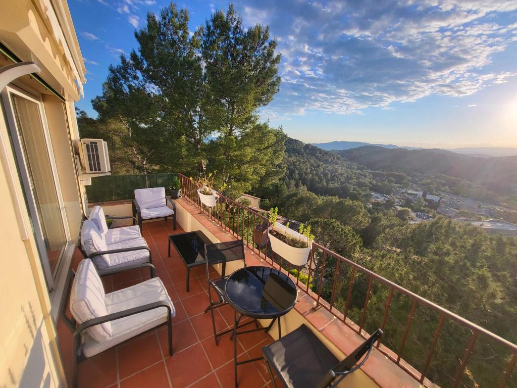 un balcon avec des chaises et une table et une vue dans l'établissement T3 avec magnifique vue montagne, 3 étoiles, piscine et parking, clim, à Mougins