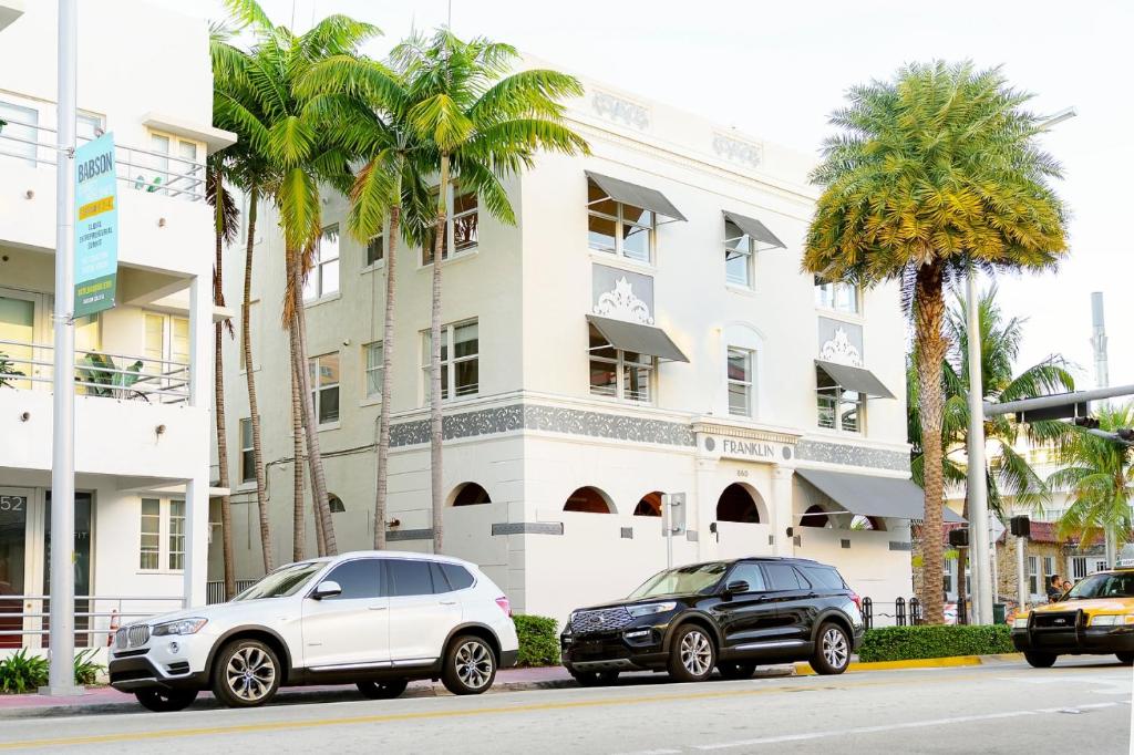dois carros estacionados em frente a um edifício em Franklin Suites South Beach em Miami Beach