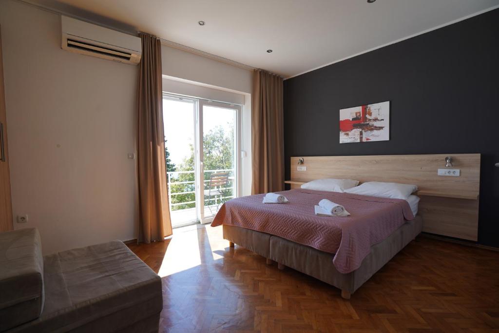 a bedroom with a large bed and a large window at Rooms Villa Lucija in Kraljevica