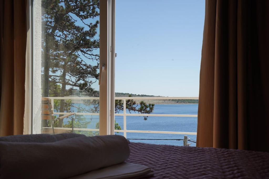 a bedroom with a large window with a view of the ocean at Rooms Villa Lucija in Kraljevica