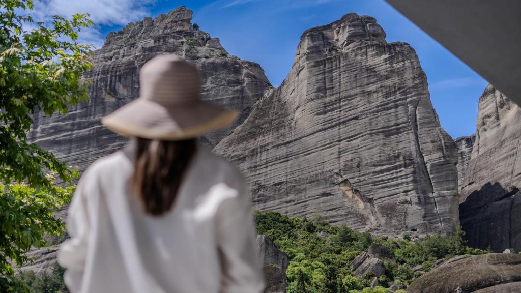 a woman wearing a hat looking at the mountains at Boutique St Stephens Residence in Kalabaka