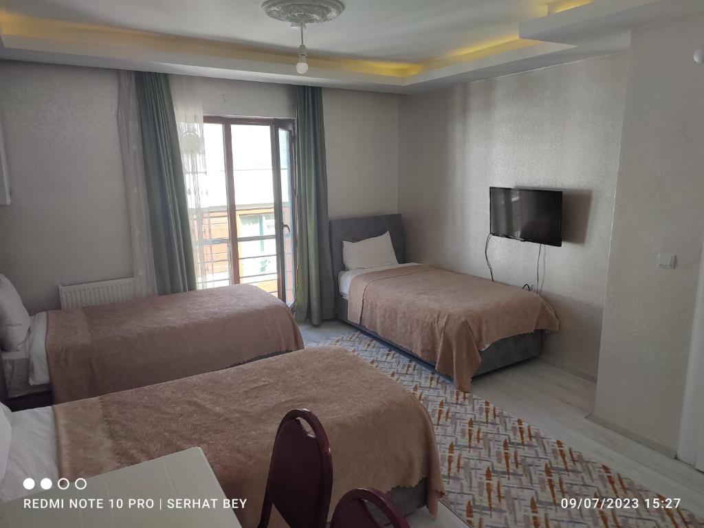 Habitación de hotel con 2 camas y TV en Espinaz Apart Otel, en Bostaniçi