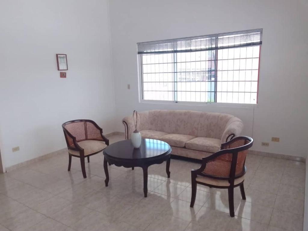 uma sala de estar com um sofá e duas cadeiras e uma mesa em Casa Nahomy em Chichiriviche