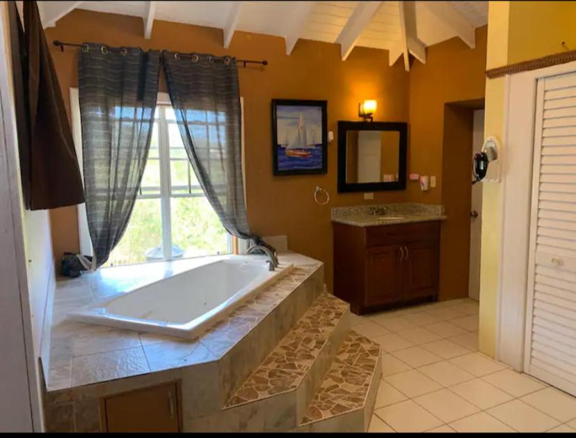 een grote badkamer met een bad en een raam bij Rest and Relax STX in Christiansted