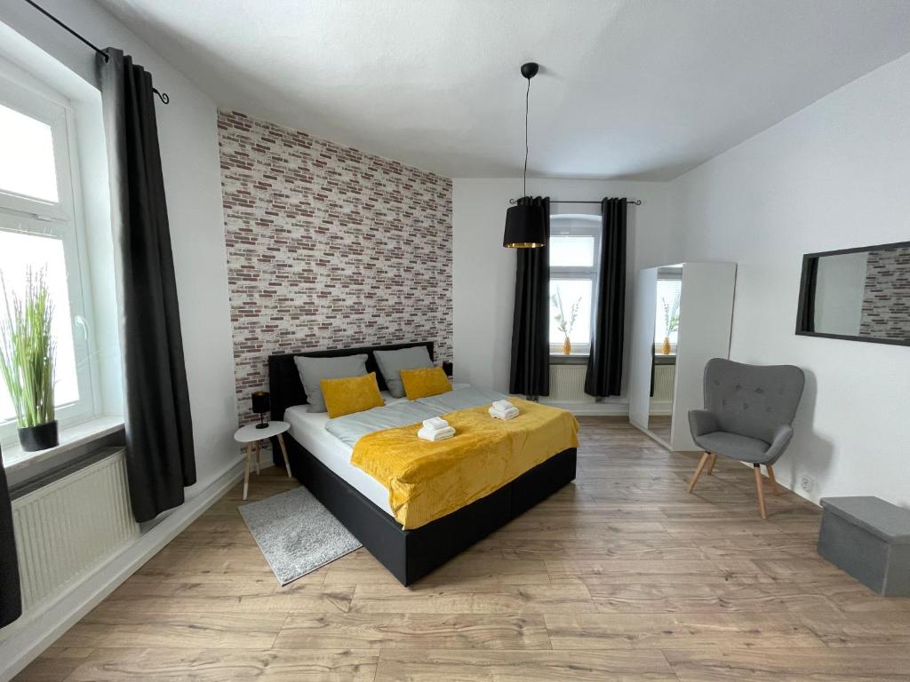 um quarto com uma cama e uma parede de tijolos em Modernes, großes City Appartement 95 qm em Meuselwitz