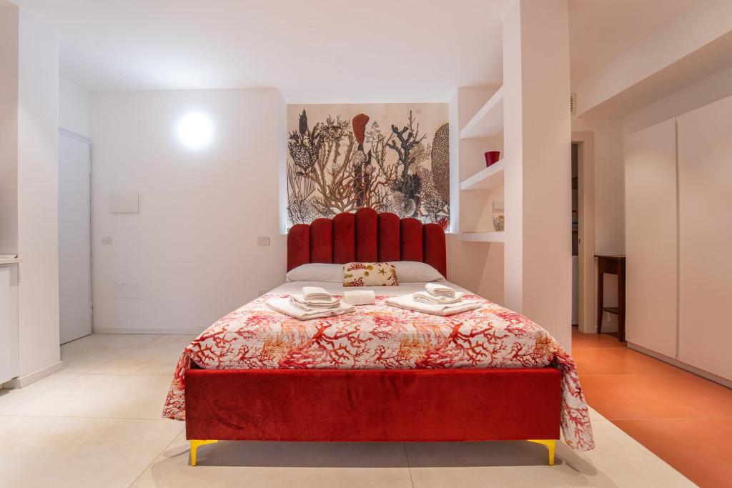 czerwone łóżko z czerwonym zagłówkiem w pokoju w obiekcie Paquja w mieście Quartu SantʼElena