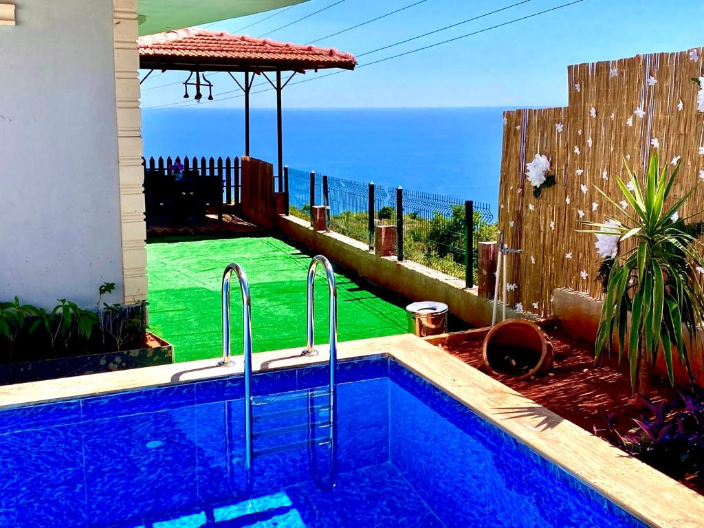 a swimming pool in a backyard with a view of the ocean at VİLLA ANATOLİA in Alanya